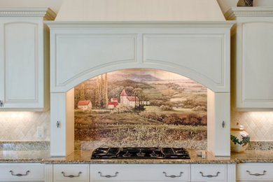 Inspiration for a southwestern kitchen remodel in Orlando with raised-panel cabinets, white cabinets, granite countertops and stone tile backsplash