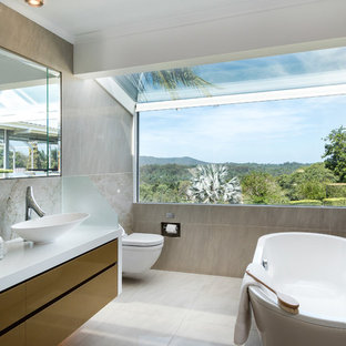 Inspiration for a mid-sized contemporary bathroom in Brisbane with flat-panel cabinets, a freestanding tub, gray tile, a vessel sink and grey floor.