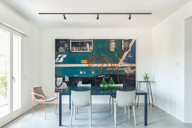 Immagine di una piccola sala da pranzo aperta verso il soggiorno design con pareti bianche, pavimento in cemento e pavimento grigio