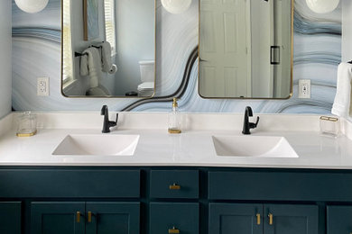 Inspiration for a mid-sized modern master white tile and ceramic tile ceramic tile, brown floor, double-sink and wallpaper bathroom remodel with flat-panel cabinets, blue cabinets, a two-piece toilet, blue walls, a drop-in sink, solid surface countertops, white countertops, a niche and a built-in vanity