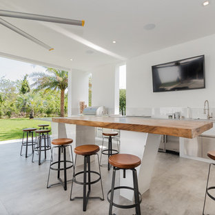 Идея дизайна: дворик в стиле модернизм с летней кухней и покрытием из бетонных плит