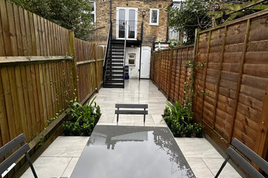 Design ideas for a small contemporary back formal partial sun garden seating for summer in London with concrete paving.