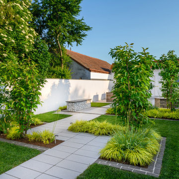 Gartenräume mit Gehölzinseln, Gräsern und geradlinigen Wegen