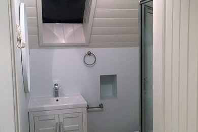 Inspiration for a small timeless 3/4 porcelain tile alcove shower remodel in Vancouver with shaker cabinets, white cabinets, a one-piece toilet, blue walls, an integrated sink and solid surface countertops