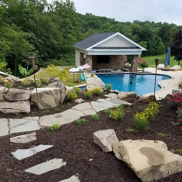 Custom pool with rock waterfalls, water slide & swim up pool bar.