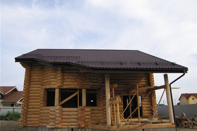 Пример оригинального дизайна: двухэтажный, деревянный частный загородный дом среднего размера с двускатной крышей и металлической крышей