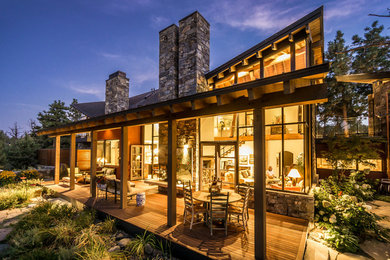 Large rustic red two-story wood exterior home idea in Other with a shed roof