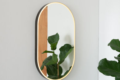 Capsula™ Capsule shaped Front Illuminated Mirror with Bronze Patina Brass Frame