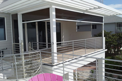 Inspiration for a mid-sized coastal screened-in back porch remodel in Tampa with a roof extension