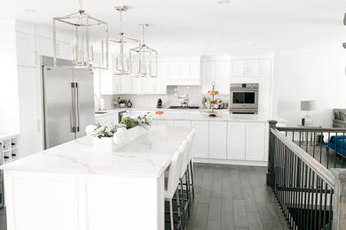 Large transitional l-shaped dark wood floor and brown floor eat-in kitchen photo in Toronto with an undermount sink, shaker cabinets, white cabinets, quartz countertops, white backsplash, ceramic backsplash, stainless steel appliances, two islands and white countertops