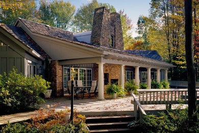 Example of a large arts and crafts beige two-story stone exterior home design in Other