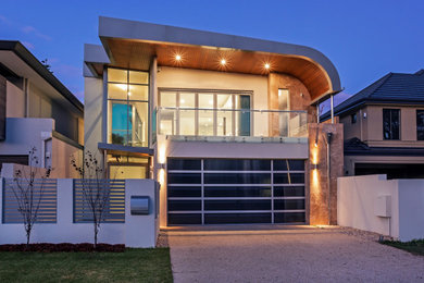 Large contemporary two-storey white house exterior in Cairns with stone veneer, a flat roof and a metal roof.