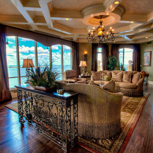 Ejemplo de salón para visitas abierto, mediterráneo, grande, con paredes verdes, suelo de madera oscura y televisor colgado en la pared