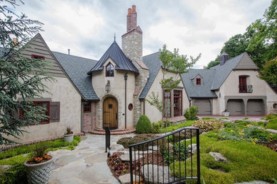 Inspiration for a huge timeless brown two-story stucco exterior home remodel in Other with a mixed material roof