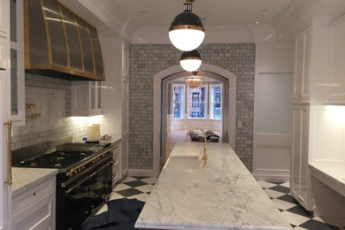 Example of a single-wall marble floor kitchen design in Boston with a farmhouse sink, recessed-panel cabinets, white cabinets, marble countertops, gray backsplash, stone tile backsplash, paneled appliances and an island