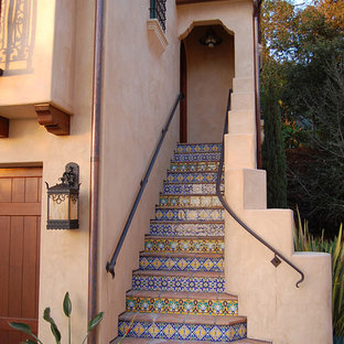 This is an example of a mediterranean straight staircase in Santa Barbara with tiled risers and terracotta treads.