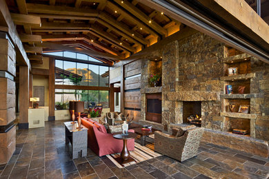 Inspiration for a rustic open concept slate floor living room remodel in Phoenix with a standard fireplace, a stone fireplace and a media wall