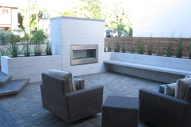 Mid-sized minimalist brick patio photo in San Diego with a fire pit and no cover
