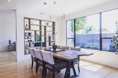 Example of a mid-sized minimalist medium tone wood floor and brown floor great room design in Sacramento with white walls and no fireplace