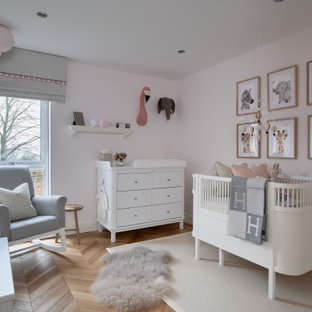 Photo of a medium sized traditional nursery for girls in Other with pink walls, medium hardwood flooring and brown floors.