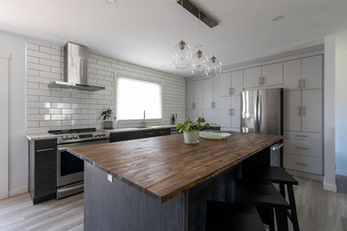 Inspiration for a mid-sized modern l-shaped gray floor eat-in kitchen remodel in Other with a double-bowl sink, flat-panel cabinets, dark wood cabinets, wood countertops, white backsplash, ceramic backsplash, stainless steel appliances, an island and multicolored countertops