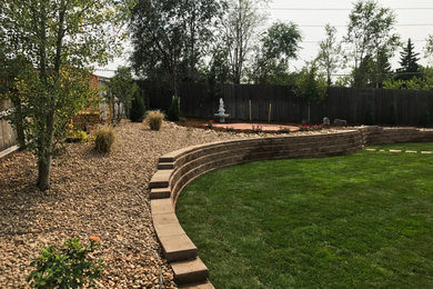 Inspiration for a large traditional full sun backyard retaining wall landscape in Denver.