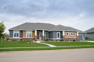 Large transitional multicolored one-story mixed siding house exterior idea in Other with a hip roof and a shingle roof