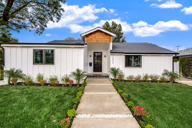 Example of a large transitional white one-story stucco and board and batten exterior home design in Los Angeles with a gambrel roof, a shingle roof and a gray roof