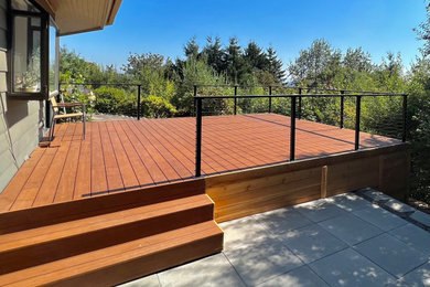 Example of a mid-century modern cable railing deck design in Portland