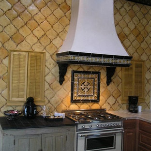 Immagine di un'ampia cucina boho chic con ante con riquadro incassato, ante in legno scuro, top piastrellato, paraspruzzi giallo, paraspruzzi con piastrelle in ceramica, elettrodomestici in acciaio inossidabile e pavimento in gres porcellanato