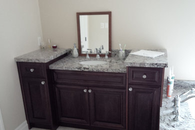 Elegant bathroom photo in Toronto with furniture-like cabinets, dark wood cabinets and granite countertops