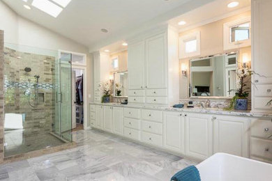 Mid-sized transitional master beige tile marble floor bathroom photo in Orange County with raised-panel cabinets, white cabinets and marble countertops