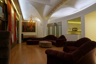 Imagen de salón abierto tradicional renovado grande sin chimenea con paredes blancas y suelo de madera en tonos medios
