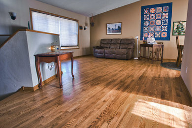 Inspiration for a mid-sized timeless medium tone wood floor family room remodel in Other