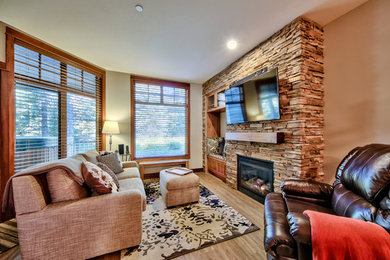 Small arts and crafts open concept vinyl floor living room photo in Vancouver with gray walls, a standard fireplace, a stone fireplace and a wall-mounted tv