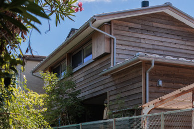 Ejemplo de fachada de casa gris pequeña de una planta con revestimiento de madera, tejado a dos aguas, tejado de metal y tablilla