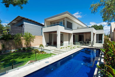 Inspiration for a large modern backyard rectangular lap pool in Adelaide with natural stone pavers.