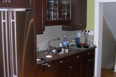 Mid-sized transitional light wood floor kitchen photo in Toronto with a double-bowl sink, shaker cabinets, dark wood cabinets, granite countertops, gray backsplash, subway tile backsplash and stainless steel appliances