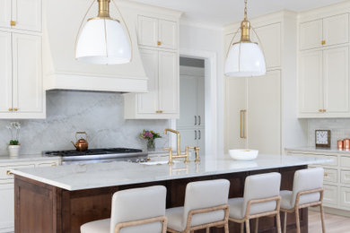Mid-sized elegant u-shaped light wood floor open concept kitchen photo in Dallas with a farmhouse sink, beaded inset cabinets, white cabinets, quartzite countertops, stone slab backsplash, paneled appliances, an island and white countertops