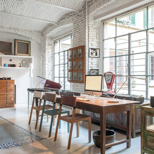 Large industrial home office in Milan with white walls and porcelain floors.