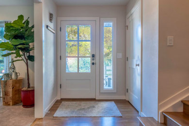 Transitional medium tone wood floor entryway photo in Denver with white walls