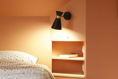 Cette photo montre une chambre parentale tendance de taille moyenne avec un mur orange, parquet clair, aucune cheminée et un sol marron.