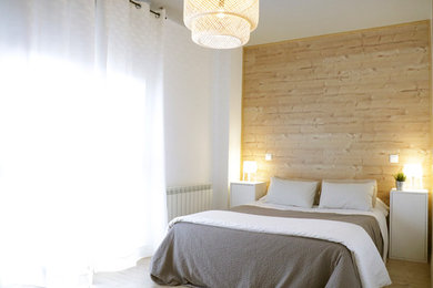 Mid-sized scandinavian bedroom in Madrid with white walls, medium hardwood floors and brown floor.
