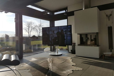This is an example of a contemporary open concept family room in Bonn with a freestanding tv.