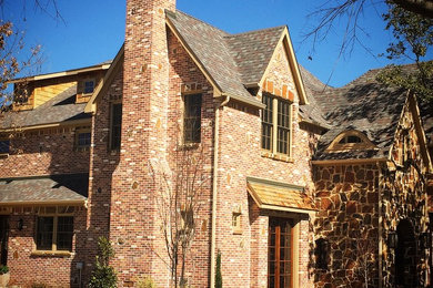 This is an example of an expansive traditional two-storey house exterior in Dallas with a gable roof and a shingle roof.