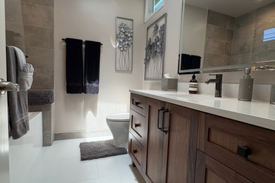 Small minimalist gray tile and porcelain tile porcelain tile and white floor bathroom photo in Los Angeles with shaker cabinets, dark wood cabinets, a one-piece toilet, beige walls, an undermount sink, quartz countertops, a hinged shower door, white countertops, a niche and a freestanding vanity