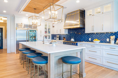 Kitchen - large transitional u-shaped light wood floor and coffered ceiling kitchen idea in Philadelphia with a farmhouse sink, flat-panel cabinets, quartzite countertops, blue backsplash, porcelain backsplash, stainless steel appliances, an island and white countertops