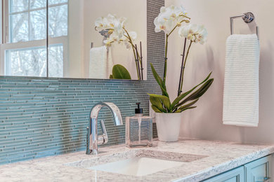 Mid-sized trendy blue tile and ceramic tile ceramic tile, beige floor and single-sink bathroom photo in Philadelphia with raised-panel cabinets, turquoise cabinets, a two-piece toilet, an undermount sink, quartz countertops, gray countertops and a built-in vanity