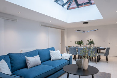 Large trendy formal and open concept ceramic tile, white floor and vaulted ceiling living room photo in Gloucestershire with white walls, no fireplace and no tv