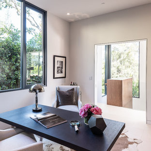Medium sized modern study in Los Angeles with white walls, limestone flooring and a freestanding desk.